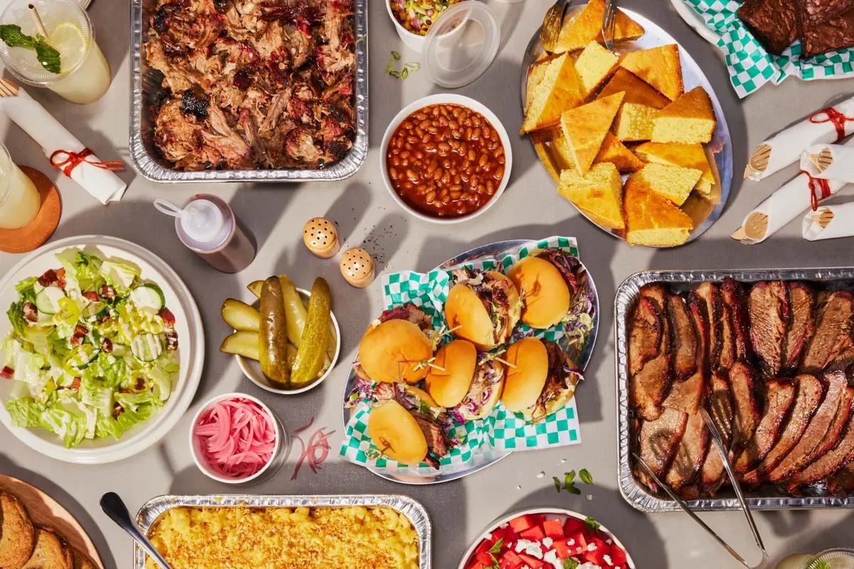 A catering spread of pulled pork, brisket, beans, cornbread and salad