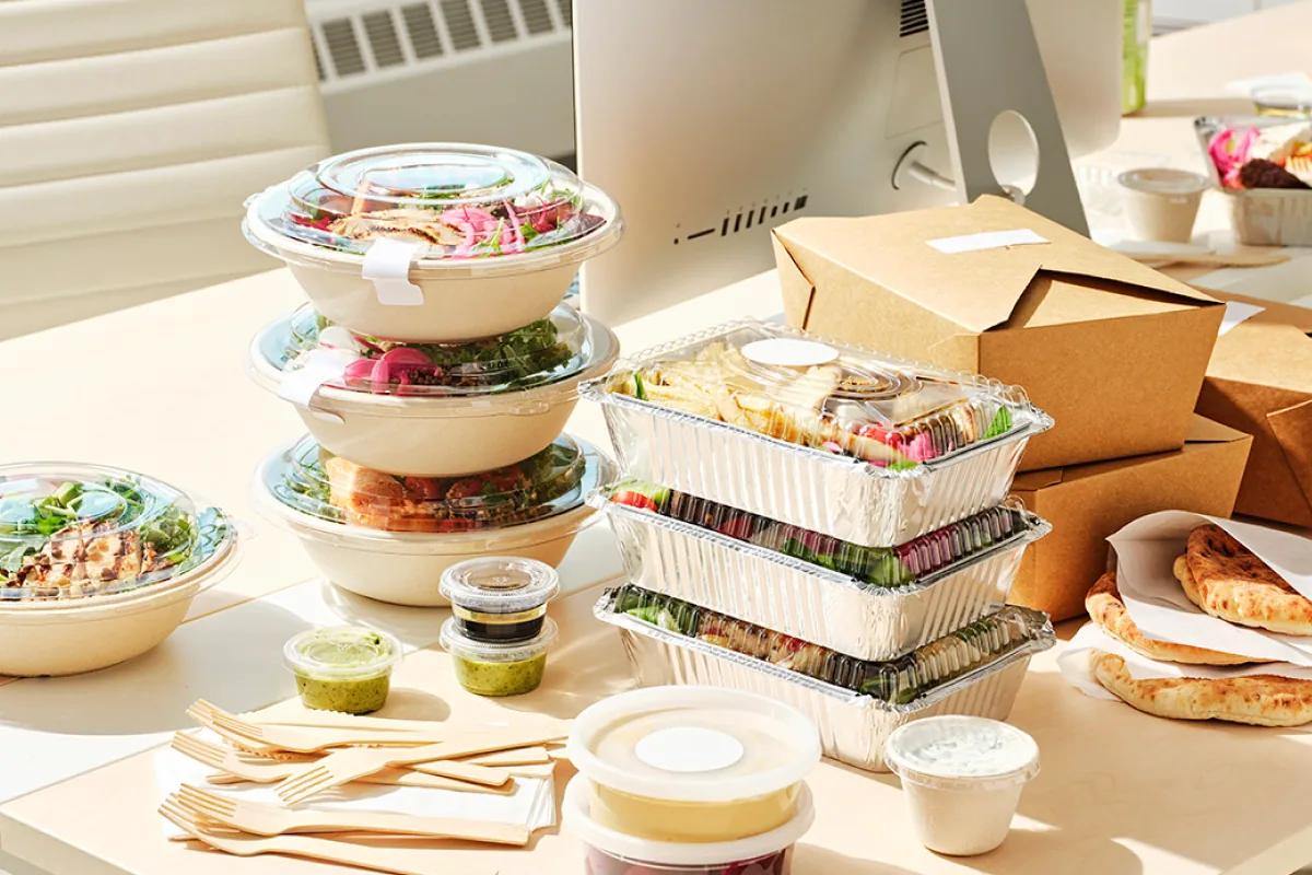Individually packed lunch bowls and boxes on an office desk